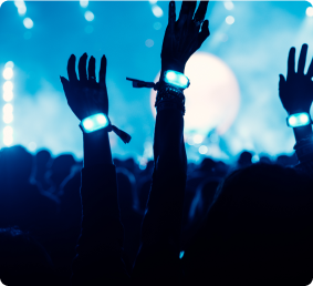 Crowd with LED wristbands raised in the air